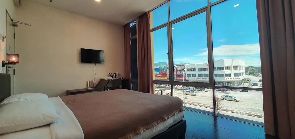 Habitación de hotel con cama y ventana grande en DS Hotel en Ipoh