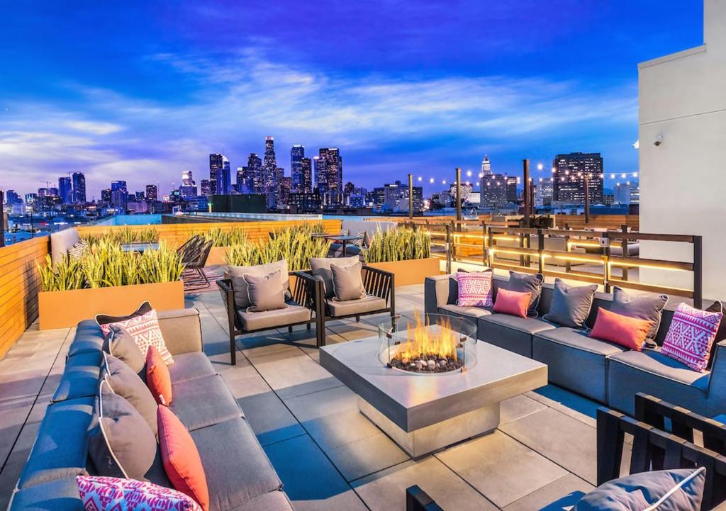 a rooftop patio with furniture and a view of the city at Apart Hotel near Dodgers Stadium in Los Angeles
