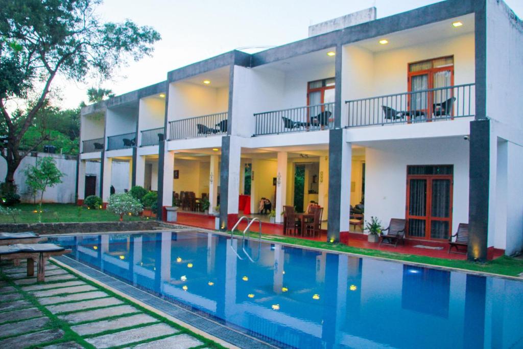 a house with a swimming pool in front of it at Amelia Resort in Sigiriya