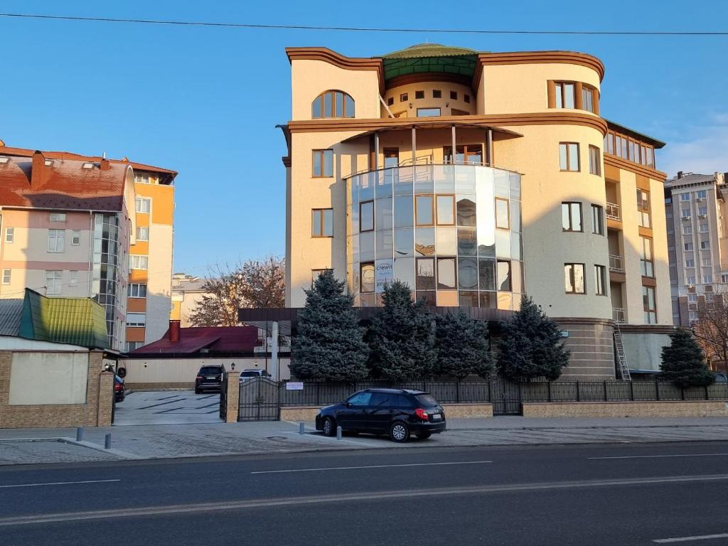 un edificio con un'auto parcheggiata di fronte di Villa ACAEM a Chişinău