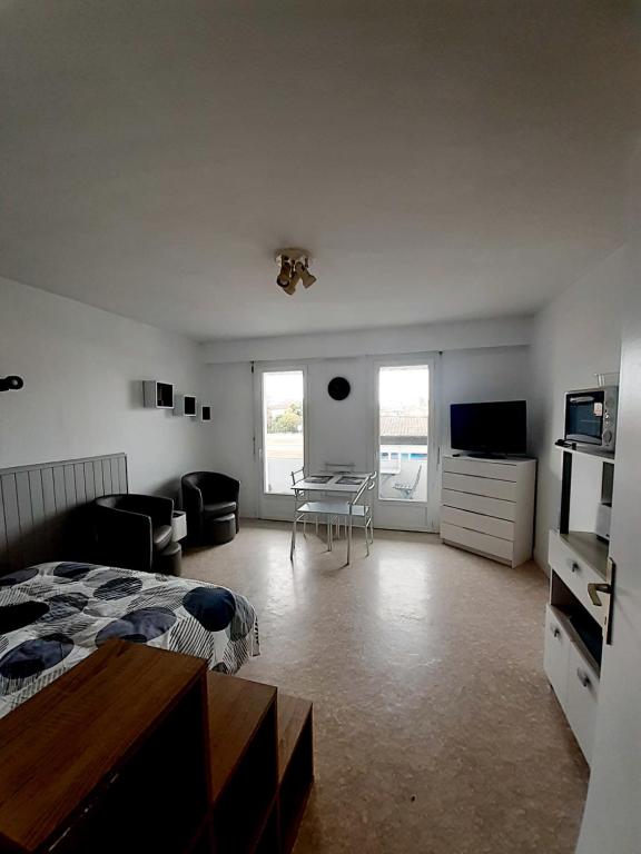 - une chambre avec un lit et un salon dans l'établissement Dax à pied! T1 2 étoiles centre ville balcon, à Dax