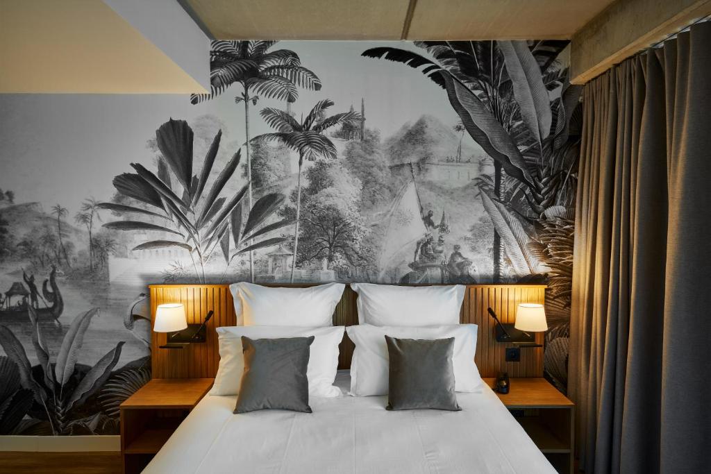 - une chambre avec un lit orné d'une fresque murale de palmiers dans l'établissement Coloft, à Lesquin