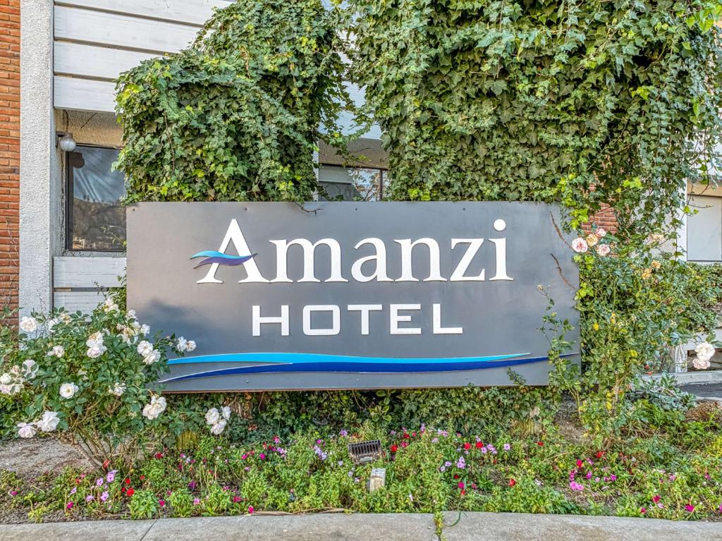Una señal para un hotel Amana delante de las flores en Amanzi Hotel, Ascend Hotel Collection, en Ventura