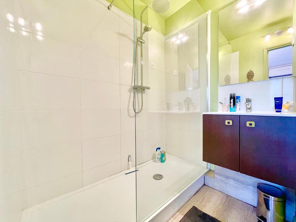 y baño con ducha, bañera y lavamanos. en ECHAPPEE CHIC - Balcon - 150 m Casino Deauville &amp; Plage, en Deauville