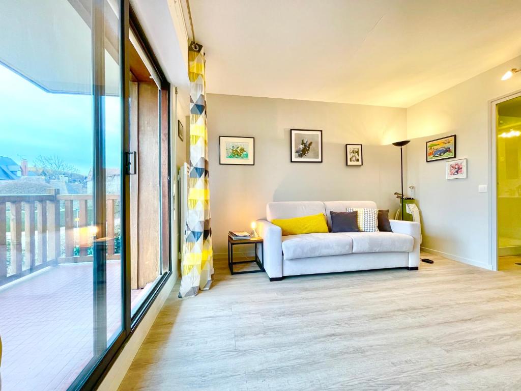sala de estar con sofá blanco y ventana en ECHAPPEE CHIC - Balcon - 150 m Casino Deauville &amp; Plage, en Deauville