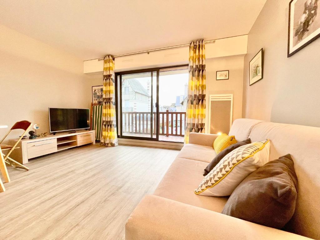 sala de estar con sofá y TV en ECHAPPEE CHIC - Balcon - 150 m Casino Deauville &amp; Plage, en Deauville