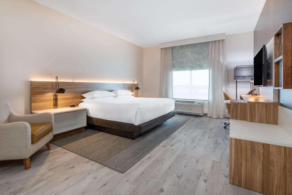 a hotel room with a bed and a desk and a television at Wyndham Garden Orlando Airport - Free Airport Shuttle in Orlando