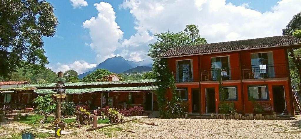 an orange house with mountains in the background at Casa Dos Artistas in Penedo