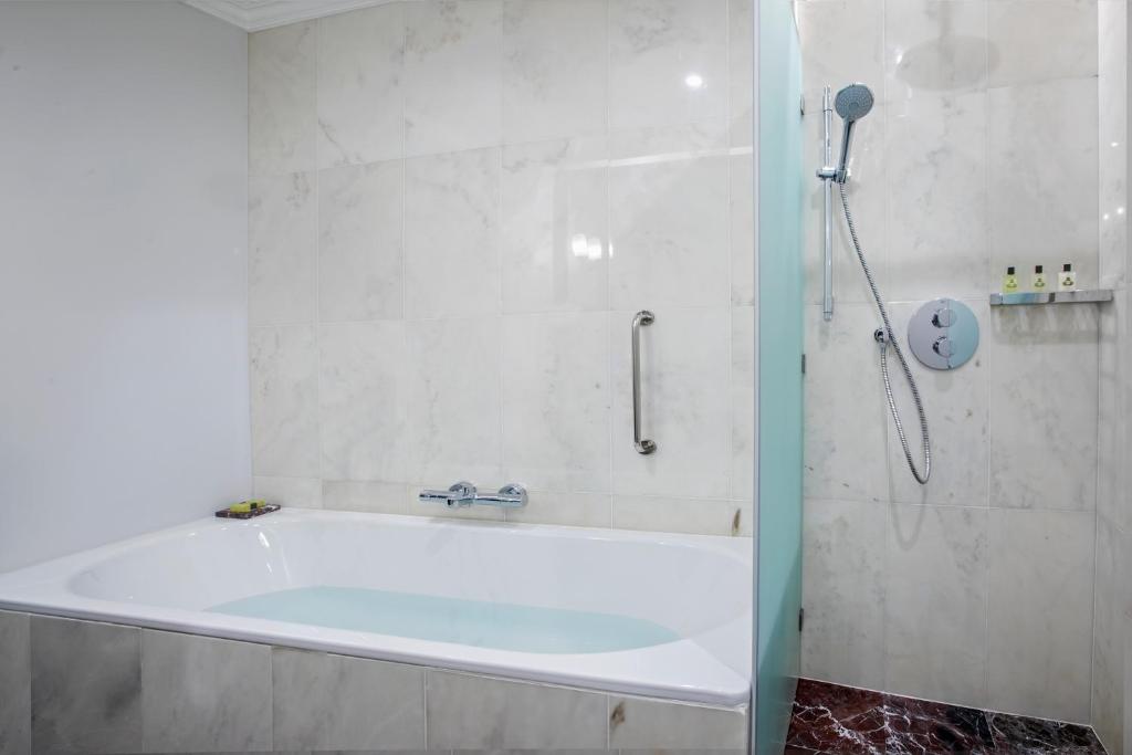 a bath tub in a bathroom with a shower at InterContinental Porto - Palacio das Cardosas by IHG in Porto