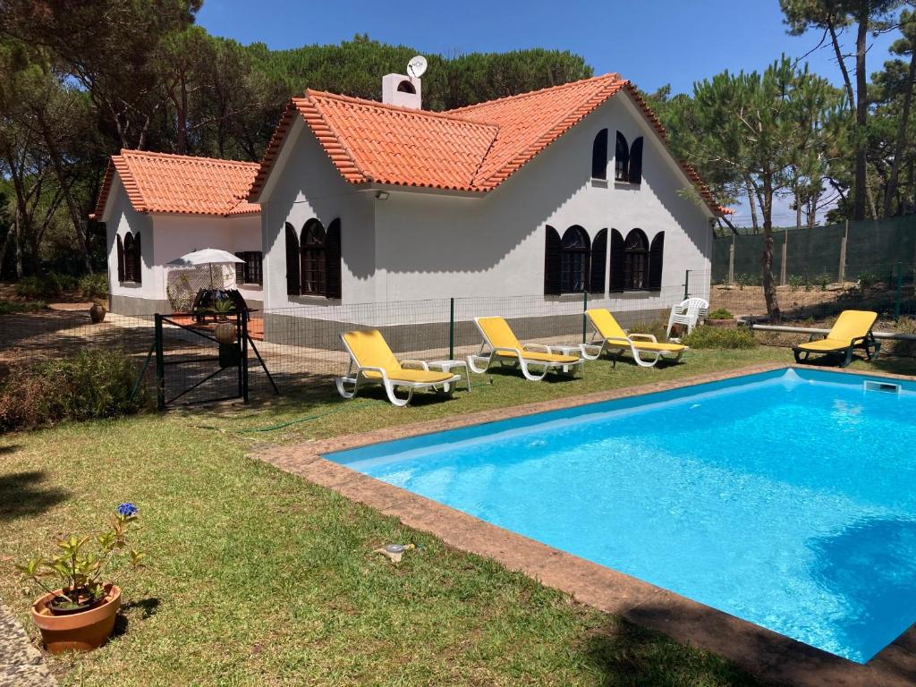 a house with a swimming pool in front of it at Moradia no Pinhal com Piscina - Espaço e Privacidade para as suas Férias! in Sintra