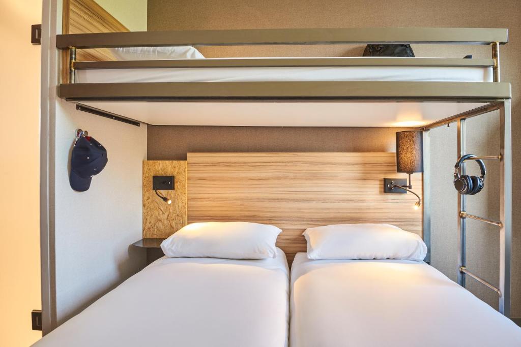 twee bedden in een kamer met twee stapelbedden bij Ibis Budget Paris porte de la Chapelle - Aréna in Parijs