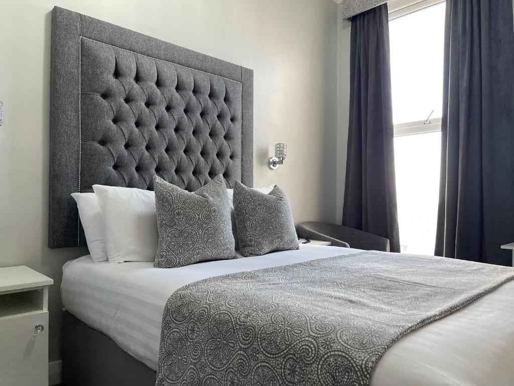 a bedroom with a large bed with a large headboard at Park House Hotel in Blackpool