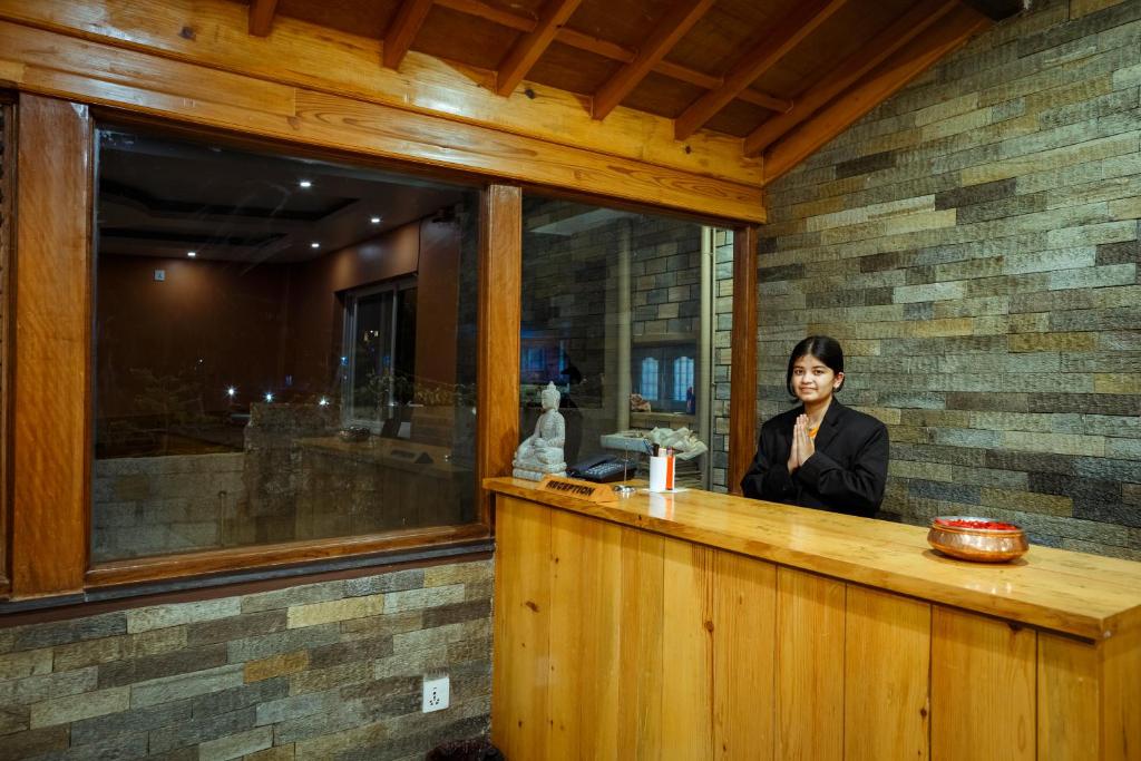 una donna seduta al bancone di un ristorante di Paradise Boutique Hotel a Pokhara
