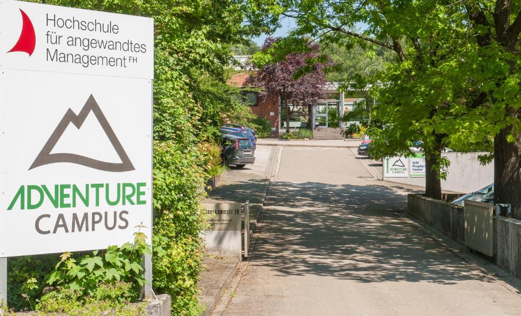 um sinal para um campus de electrodomésticos ao lado de uma rua em Adventure Campus em Treuchtlingen