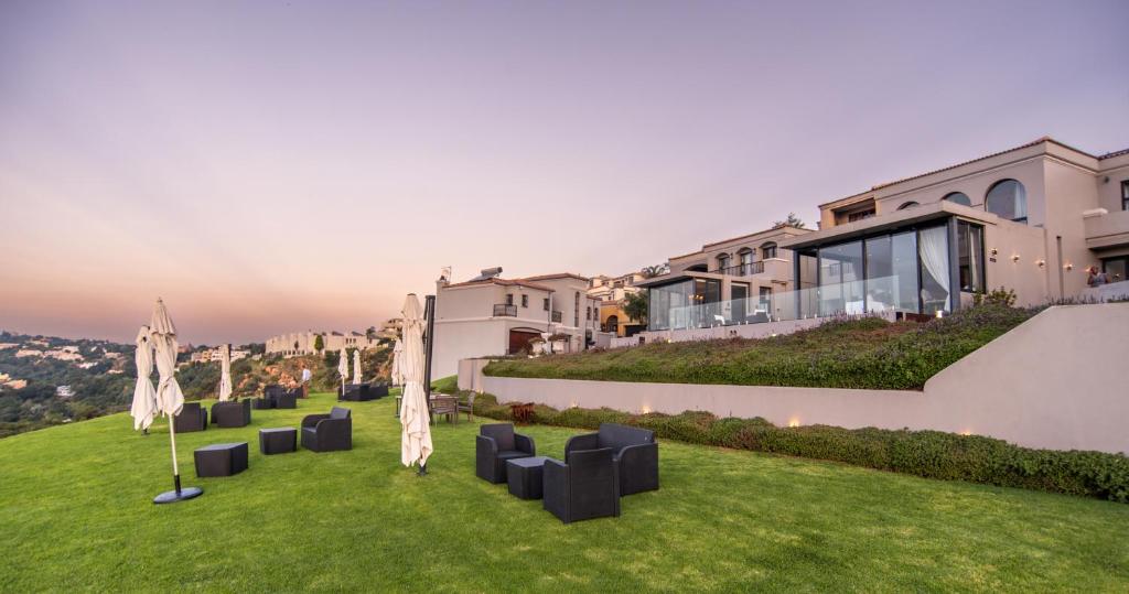 una fila di sedie nere su un prato di fronte a un edificio di The Northcliff Boutique Hotel a Johannesburg