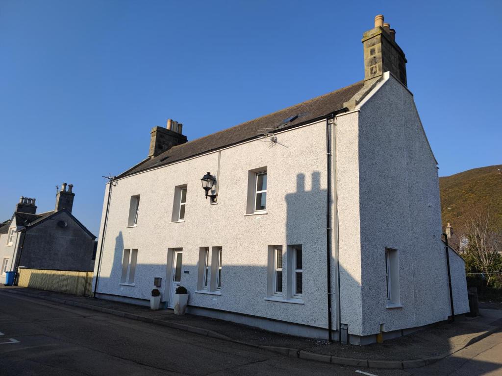 een wit gebouw aan de straatkant bij Dunvegan House in Helmsdale