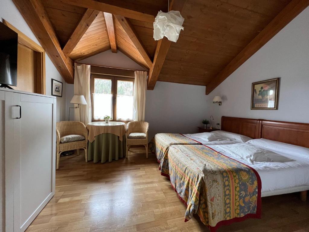um quarto com 2 camas e uma mesa em Hostal Rural Salazar em Oronz