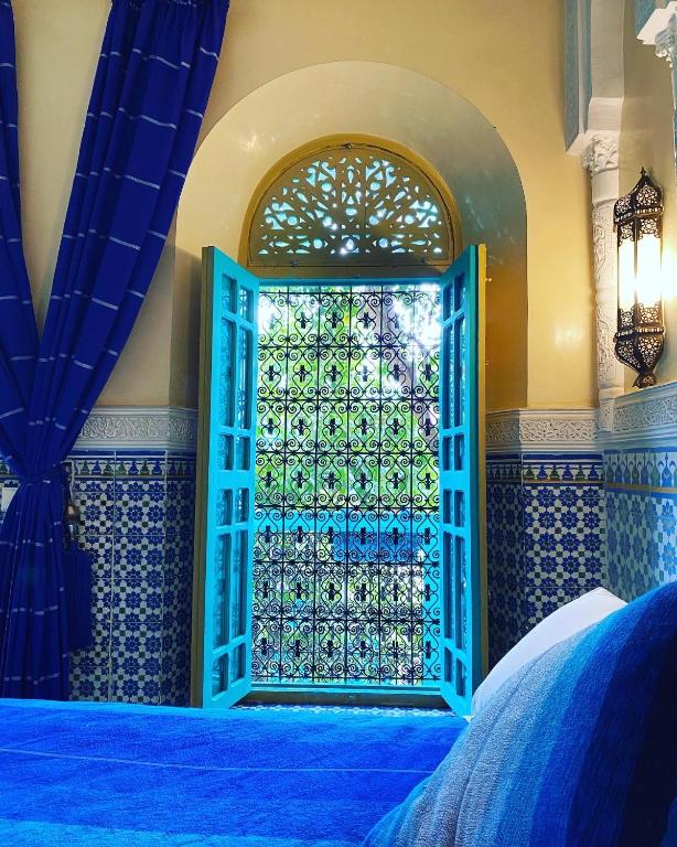 an open door in a room with blue tiles at Riad Al Nour in Marrakech