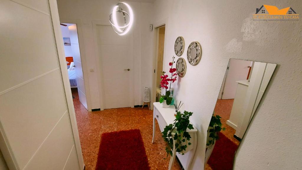 um corredor com uma parede branca com relógios e flores em Apartamento La Pobla de Farnals em Valência