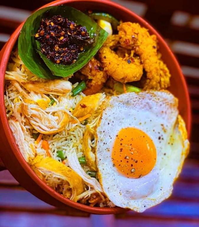 a bowl of food with an egg and noodles at Goyambokka Guesthouse in Tangalle