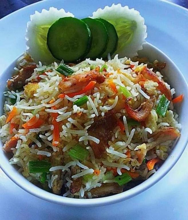 a bowl of food with rice and vegetables and pickles at Goyambokka Guesthouse in Tangalle