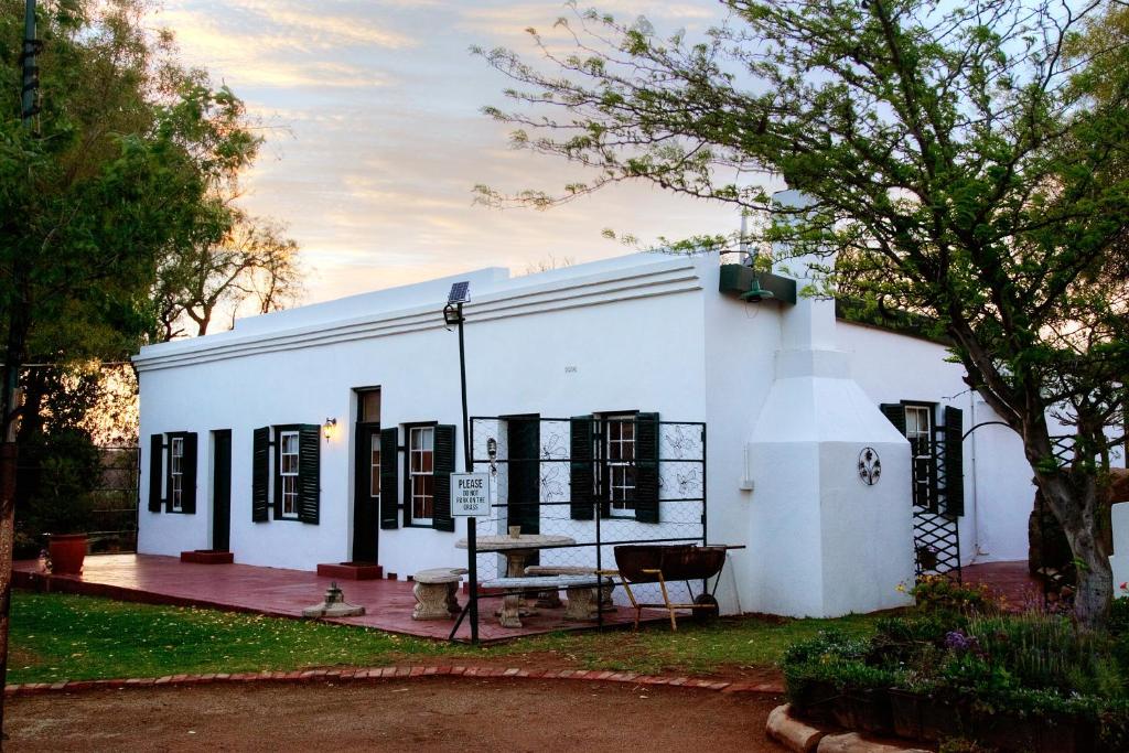 a white building with a bench in front of it at Finchley Farm Cottages in Willowmore