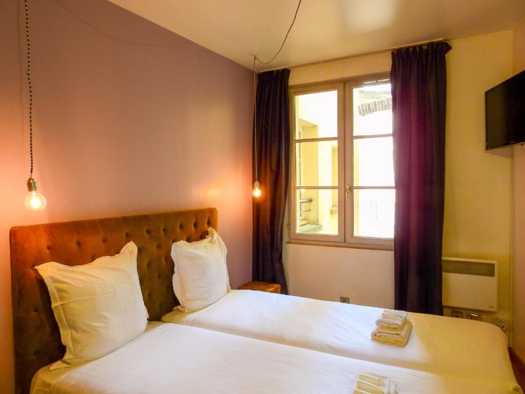 una camera da letto con un letto con lenzuola bianche e una finestra di 301 - Studio tout confort au cœur de Paris 5 a Parigi