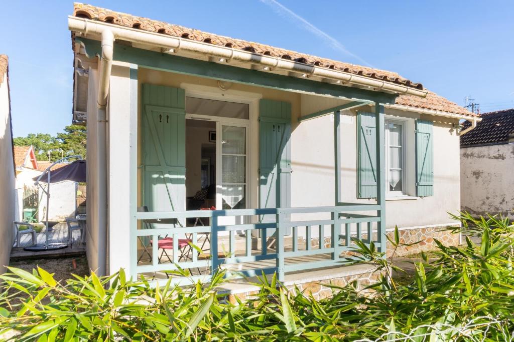 ein kleines Haus mit einer grünen und weißen Veranda in der Unterkunft Maison de bourg a deux pas de la mer in Saint-Brevin-les-Pins