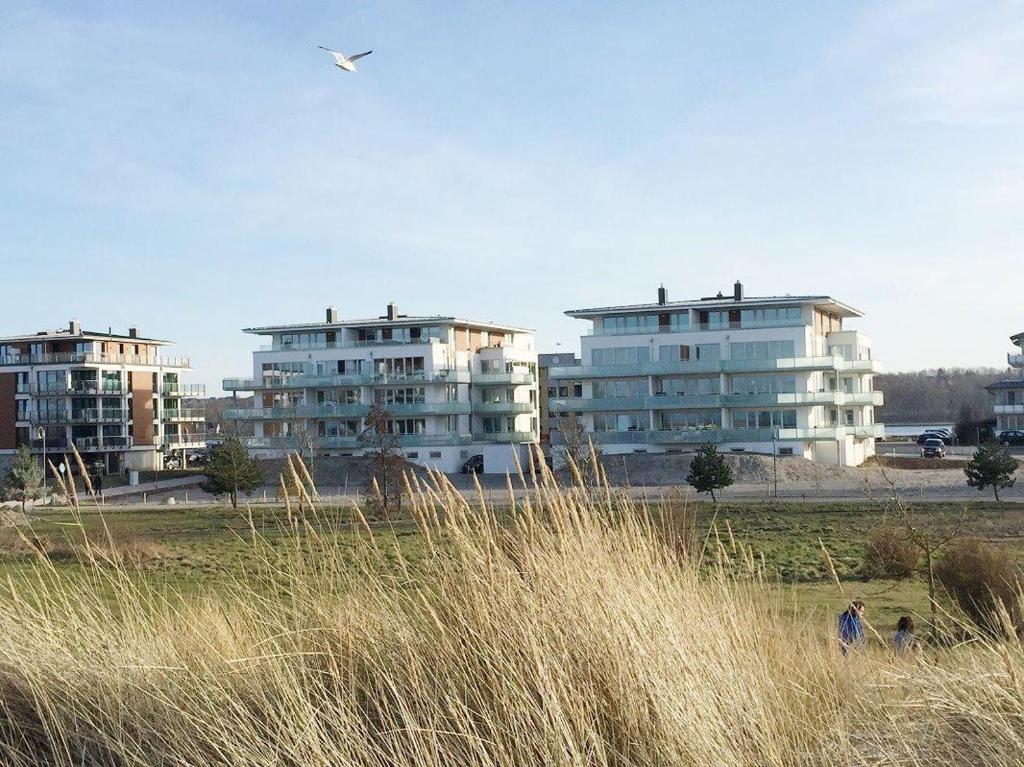 una cometa está volando sobre algunos edificios altos en Duenenpark-Heiligenhafen-Haus-Meerduene-Wohnung-2-Meertraum, en Heiligenhafen