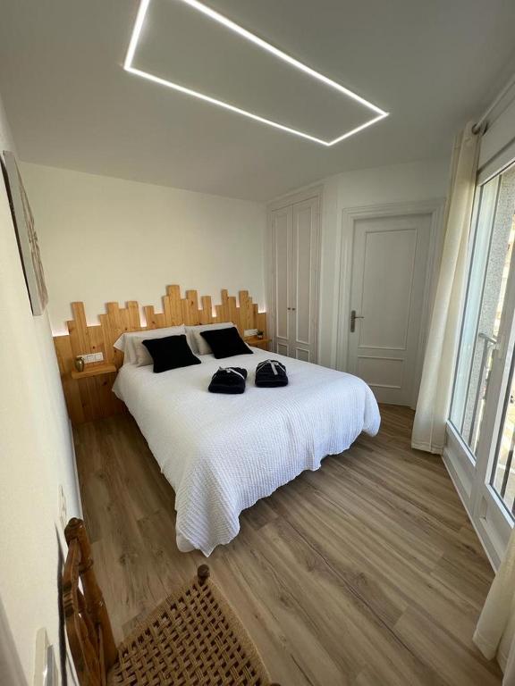 sypialnia z dużym białym łóżkiem i drewnianą podłogą w obiekcie Apartamento Esperanza by Altea Blanca Apartamentos Turísticos w Altei