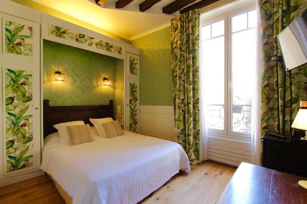 Un pat sau paturi într-o cameră la Hotel de la Bretonnerie