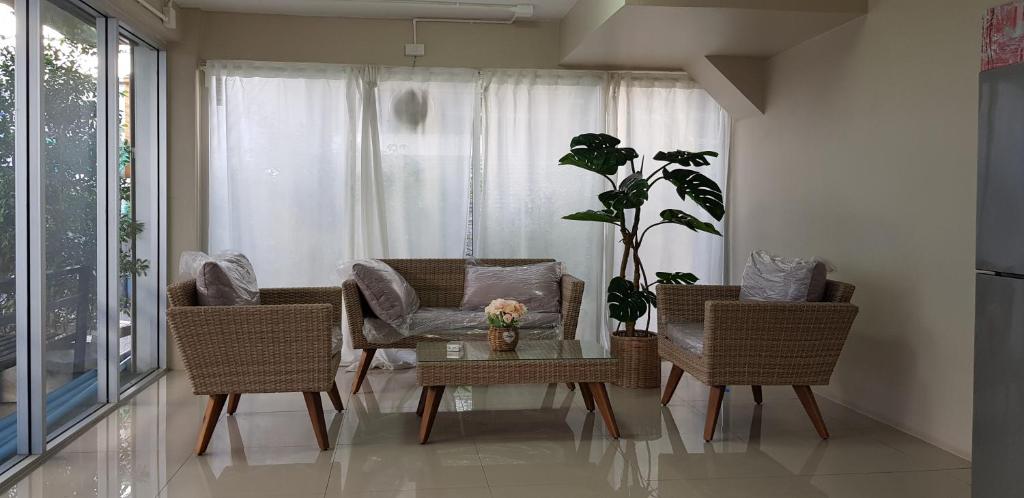 un soggiorno con sedie e tavolo con una pianta di Checkin Hostel @DonMuang Airport a Bangkok