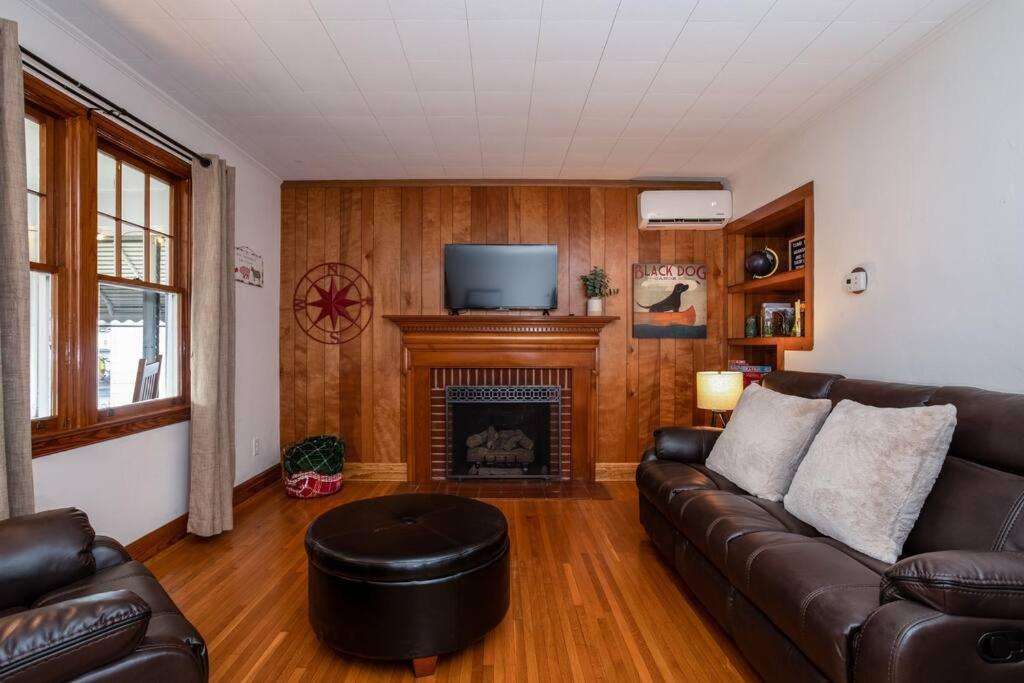 a living room with a leather couch and a fireplace at Shenandoah Getaway Near National Park Cozy Space! in Shenandoah