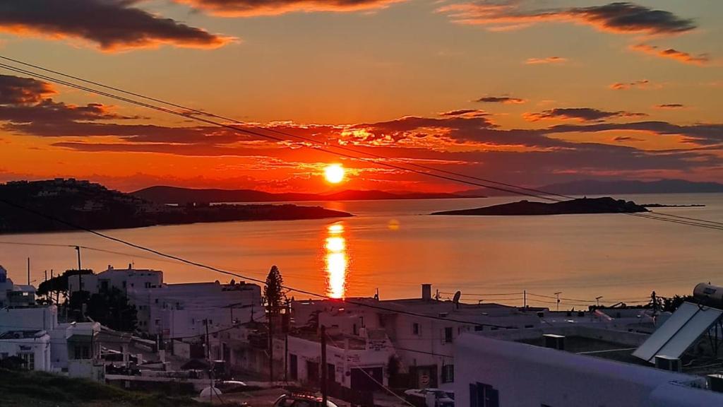 um pôr-do-sol sobre uma cidade com um corpo de água em Fabrica Sunset Apartments em Megali Ammos