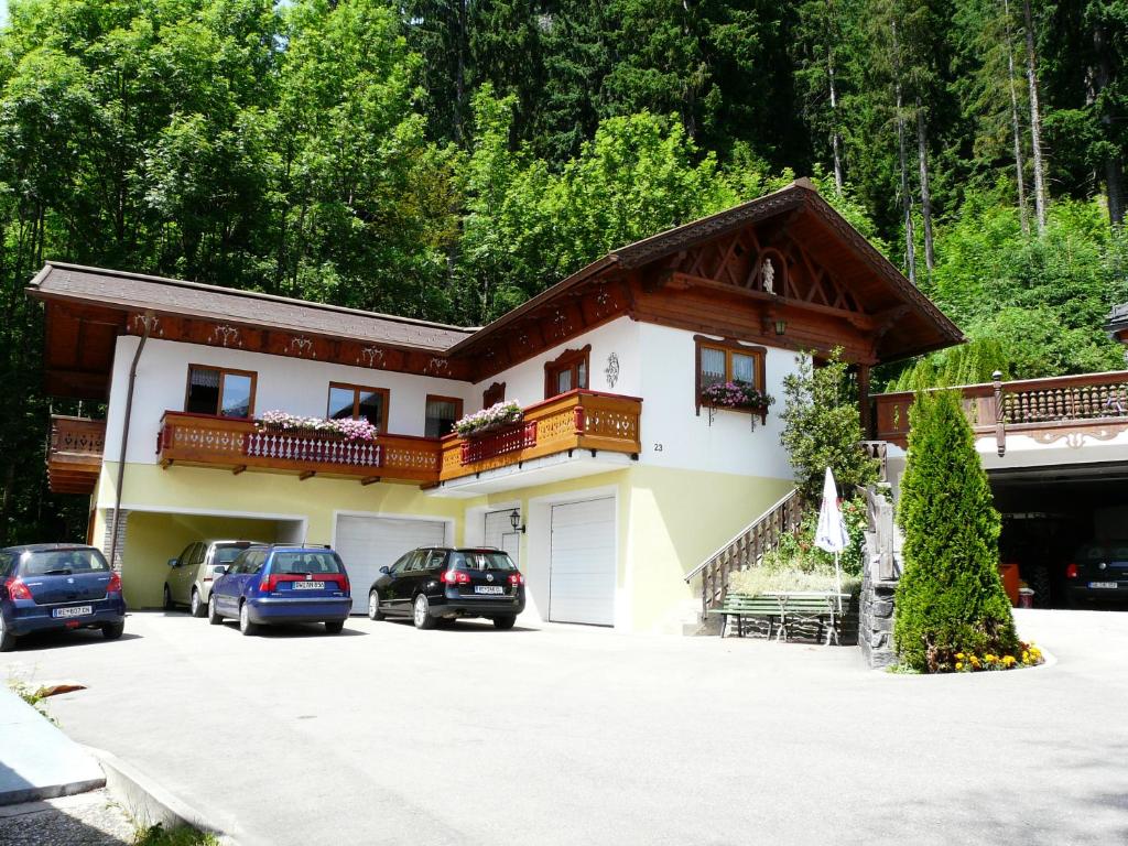 une maison avec des voitures garées devant elle dans l'établissement Landhaus Schatz, à Nesselwängle