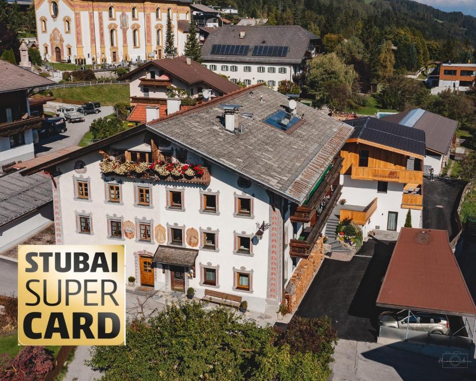 - une vue sur un bâtiment blanc avec un panneau dans l'établissement Apartment Edith, à Telfes im Stubai