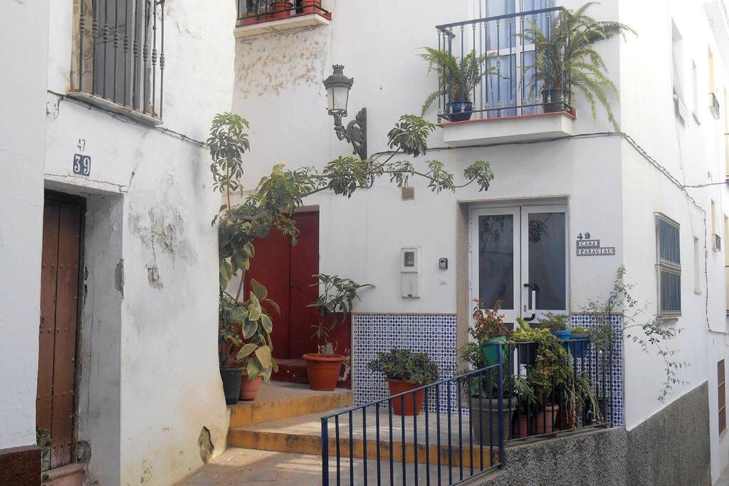 un edificio bianco con una porta rossa e piante in vaso di Andalusien pur auf drei Etagen a Torrox