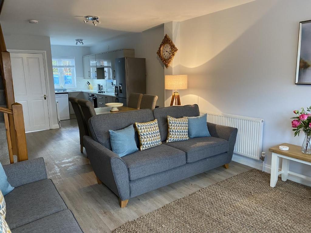 uma sala de estar com um sofá e uma cozinha em The Sorting House em Hunstanton