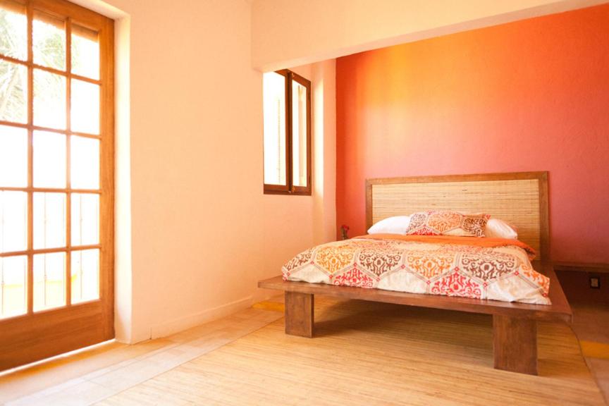 a bedroom with a bed and a wooden bench at Hostal San Pancho in San Francisco