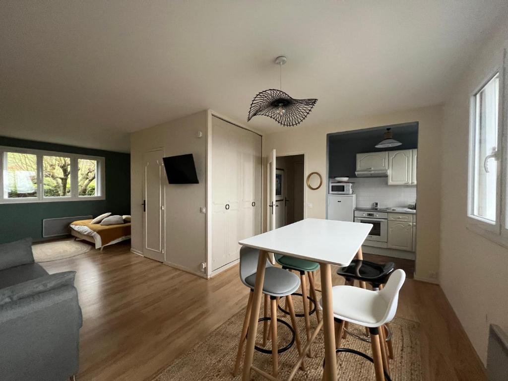 une cuisine et un salon avec une table et des chaises dans l'établissement le chat perché, à Honfleur