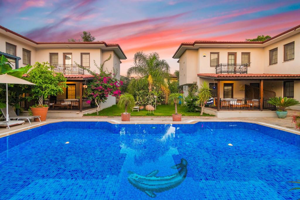 a swimming pool in front of a house at Mavi Deniz Konuk Evi in Selimiye