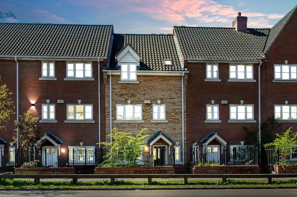 un edificio de ladrillo con una valla delante en Balcony Parking 50mbps Full Kitchen Washer, en Norwich