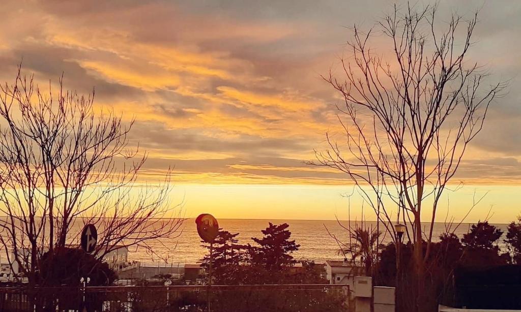 un tramonto sull'oceano con un aquilone nel cielo di A Due Passi dal Mare B&B a Scalea