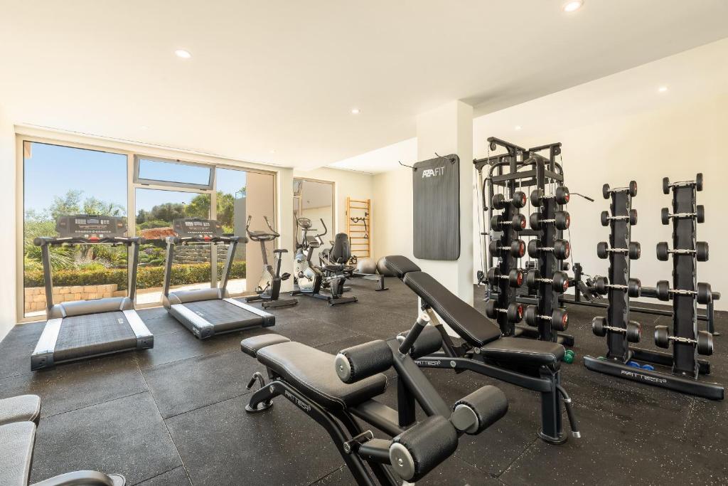 a gym with several tread machines in a room at Caneiros Luxury House & Suites in Ferragudo