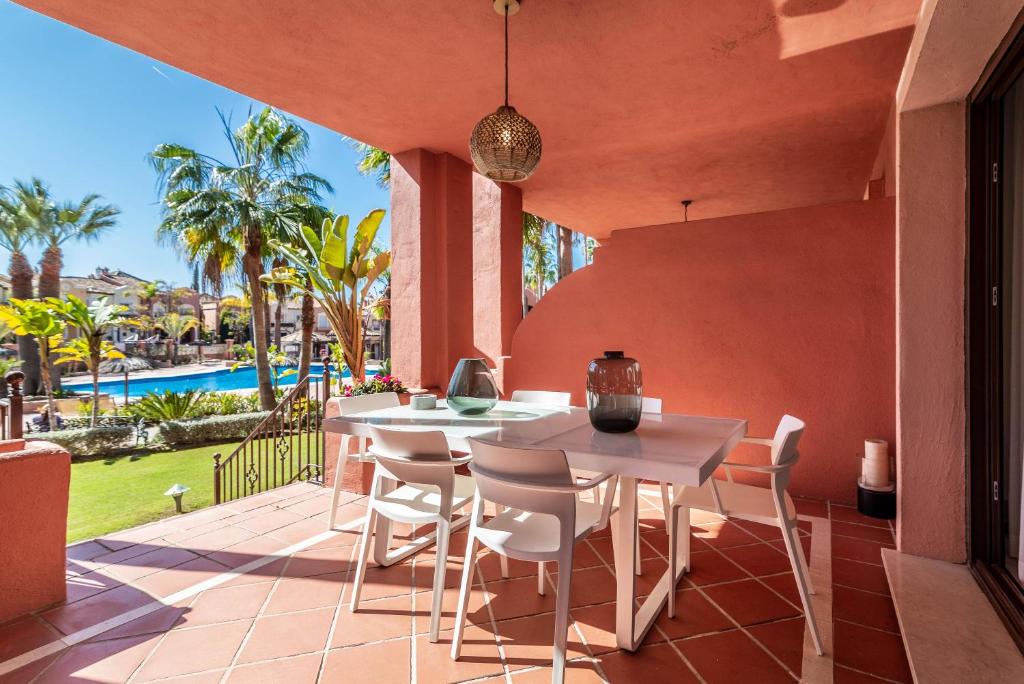 un patio al aire libre con una mesa y sillas blancas en Solvasari, en Marbella