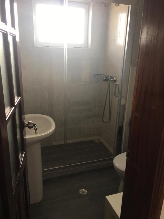uma casa de banho com um chuveiro, um lavatório e um WC. em Apartamento Coral em Santa Maria
