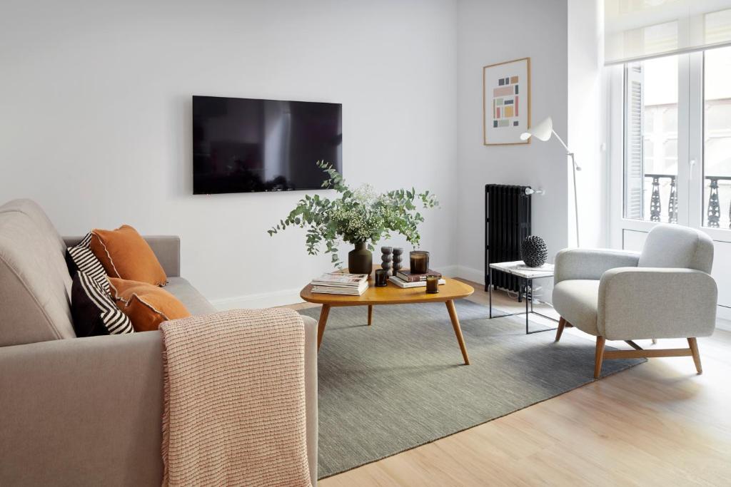 una sala de estar con un sofá y una mesa en Mayor Suite 2 by FeelFree Rentals, en San Sebastián