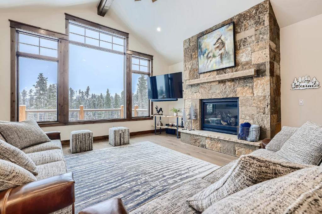 un salon avec une cheminée en pierre et une télévision dans l'établissement Deere Retreat Home Hot Tub Stylish, à Breckenridge