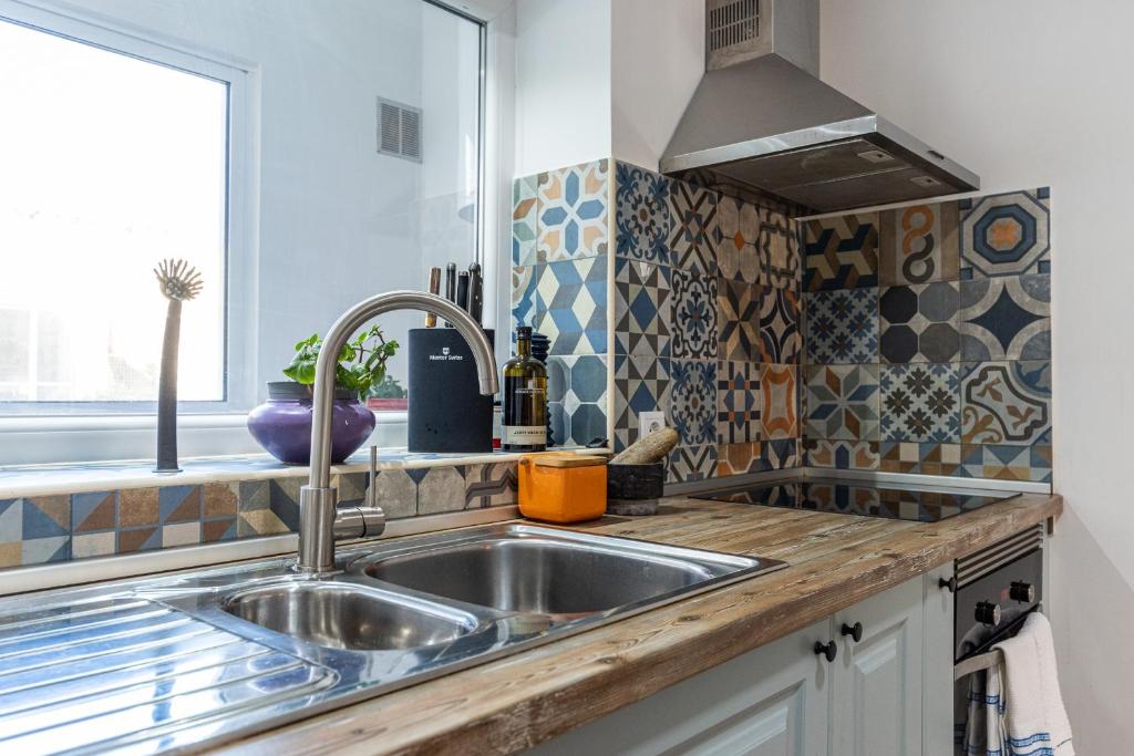 a kitchen with a sink and a window at Casa das Rosas by MP in Vila Nova de Gaia