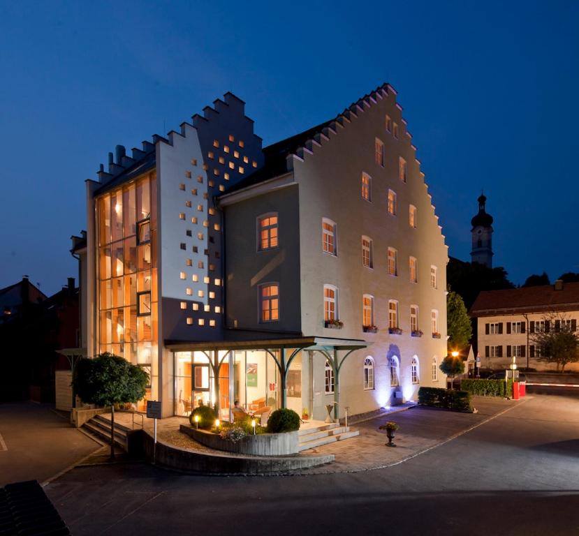 ein großes Gebäude in einer Stadt in der Nacht in der Unterkunft Hotel Angerbräu in Murnau am Staffelsee